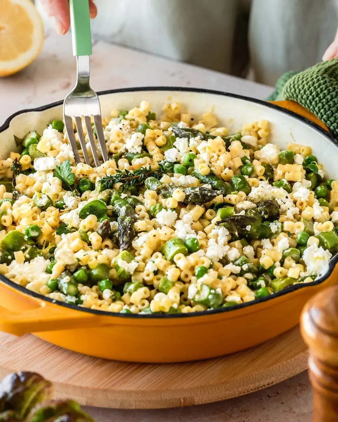 Eine Gabel sticht in die One-Pot Spargel-Nudel-Pfanne mit Erbsen, Feta und Thymian