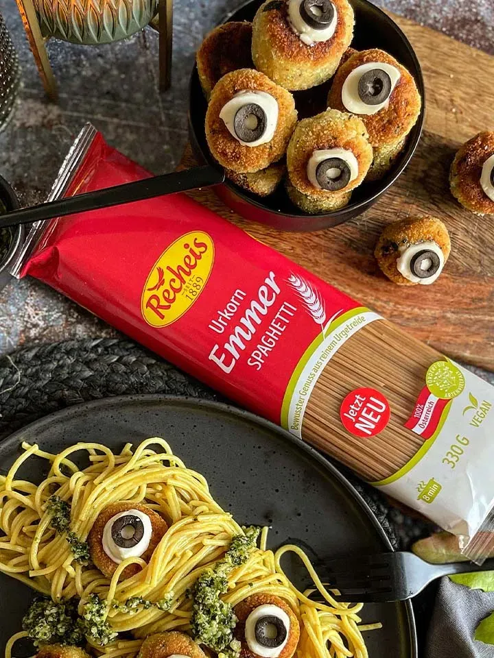 Spaghetti mit cremiger Currysauce und Gemüseaugen zu Halloween, neben Packung Emmer-Spaghetti