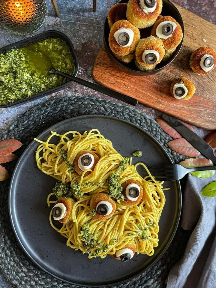 Spaghetti mit cremiger Currysauce, Bratlingen und Oliven als Augen, mit grünem Pesto, zu Halloween