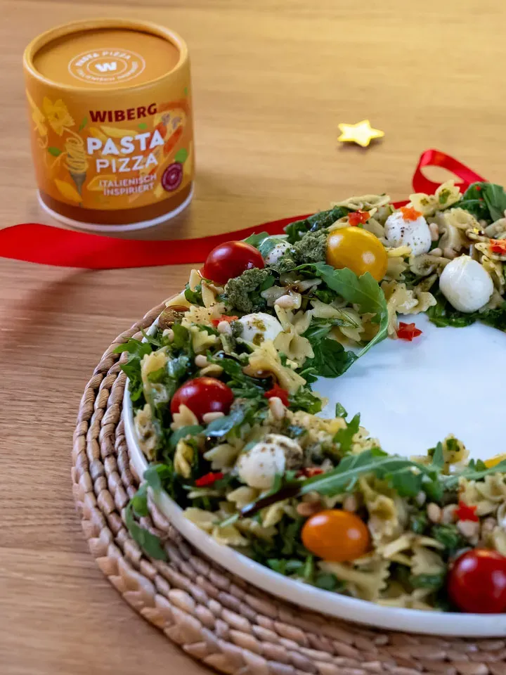 Caprese-Nudelsalat in Kranzform mit Tomaten und Mozzarella, daneben Wiberg Pasta-Pizza-Gewürz