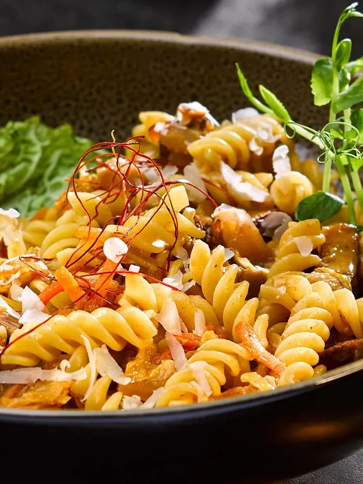 Nahaufnahme: Carbonara mit Kimchi, Fusilli mit Gemüse und Kräutern in einer Schüssel