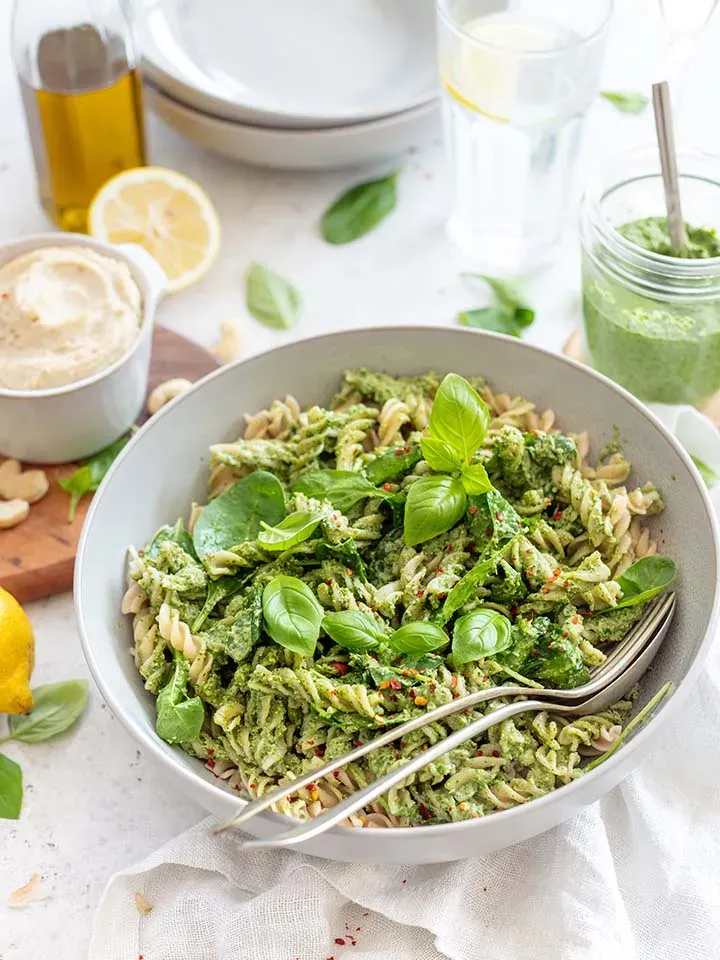 Dralli mit Spinatpesto und Cashew in einer Schüssel, mit frischem Basilikum garniert