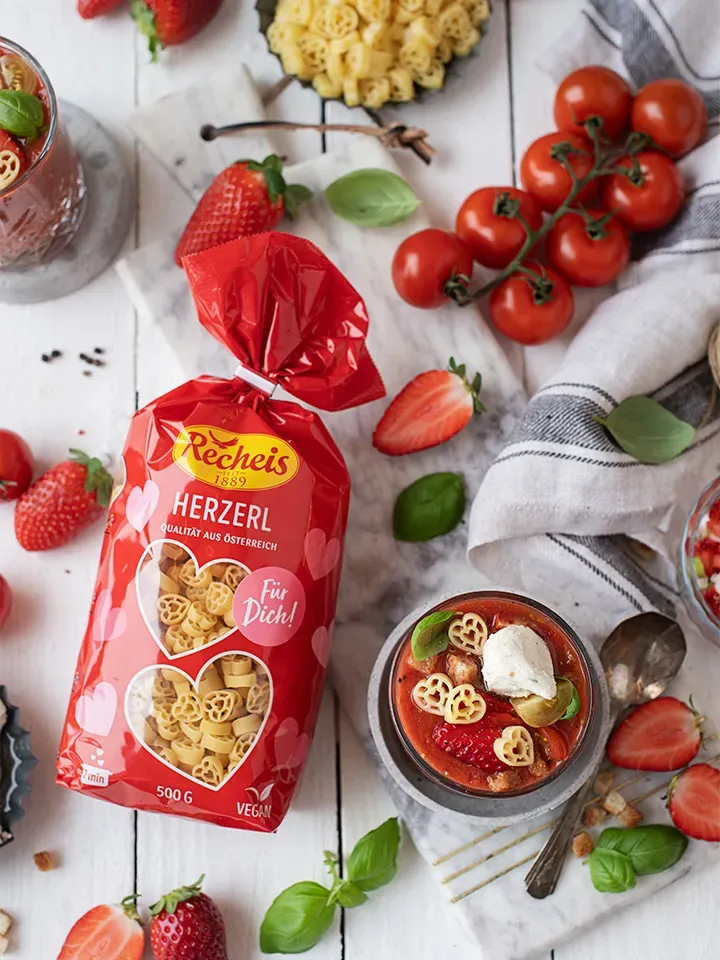 Verpackte Recheis Herzerl Nudeln mit frischen Tomaten, Erdbeeren und Basilikum auf einem Tisch
