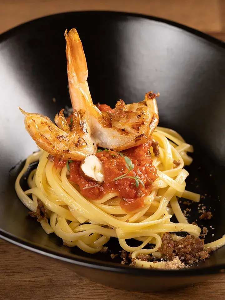 Fettuccine Pomodoro mit Alpengarnelen in schwarzer Schüssel, Gastrorezept