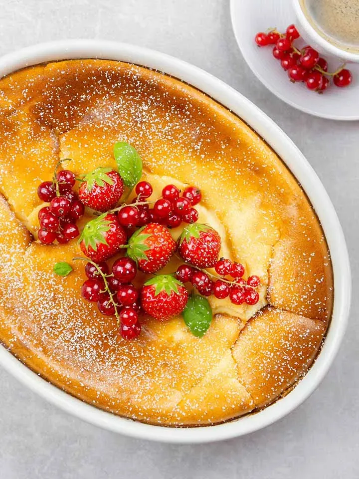 Grießauflauf mit Beeren aus Hartweizengrieß, mit Puderzucker in einer weißen Form