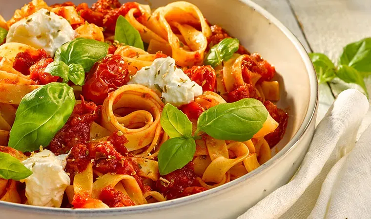 Tagliatelle al Pomodoro mit Basilikum und Käse in einer Schüssel