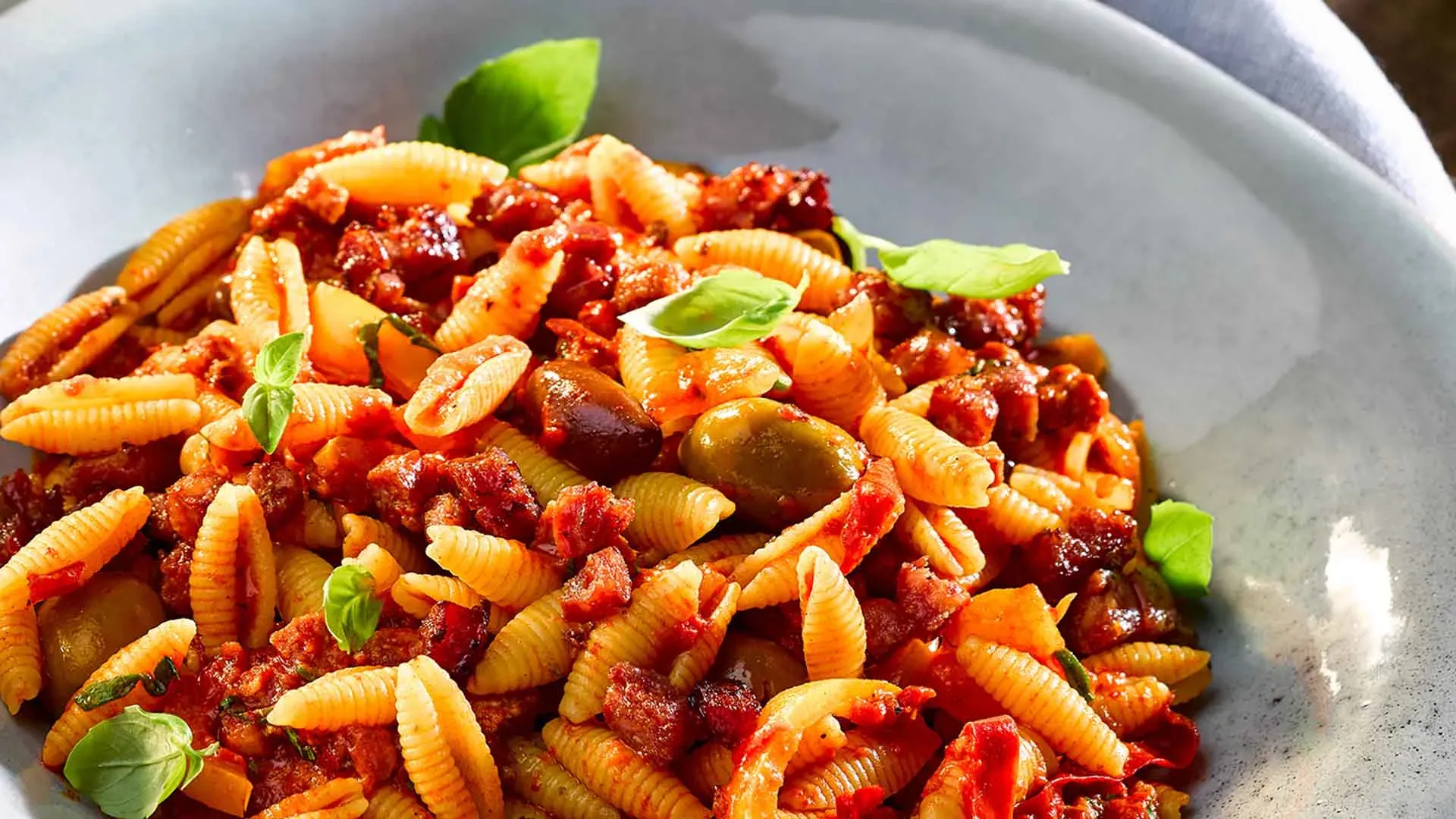 Gnocchi sardi mit Salsiccia und Peperonata in Tomatensauce mit Oliven und Basilikum