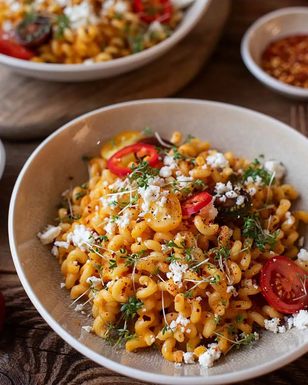 Goldlöckchen mit cremiger Paprikasauce, Kirschtomaten, Kräutern und zerbröckeltem Käse in einer Schüssel