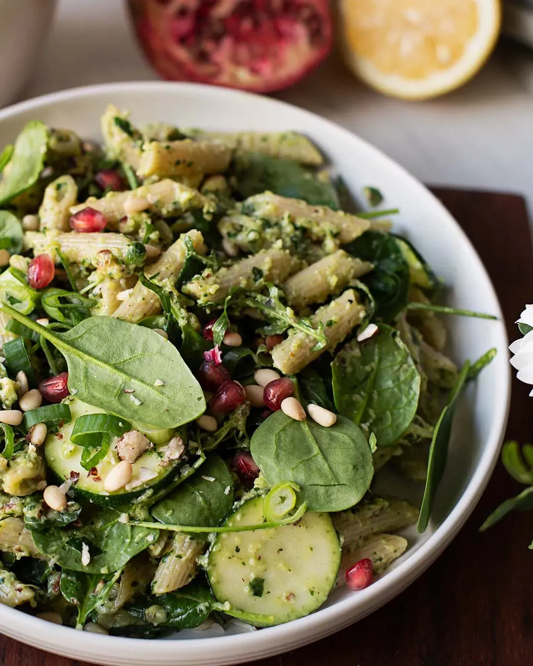 Green-Goddess-Dinkelnudelsalat in einer Schüssel mit Spinat, Zucchini, Pinienkernen und Granatapfelkernen