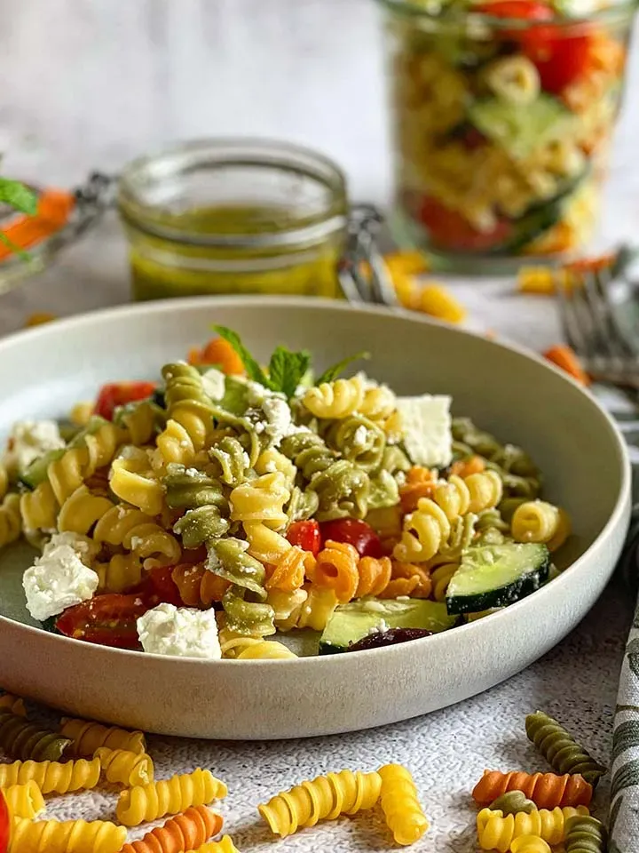 Griechischer Salat mit Nudeln, Feta, Gurken und Tomaten in einer weißen Schüssel