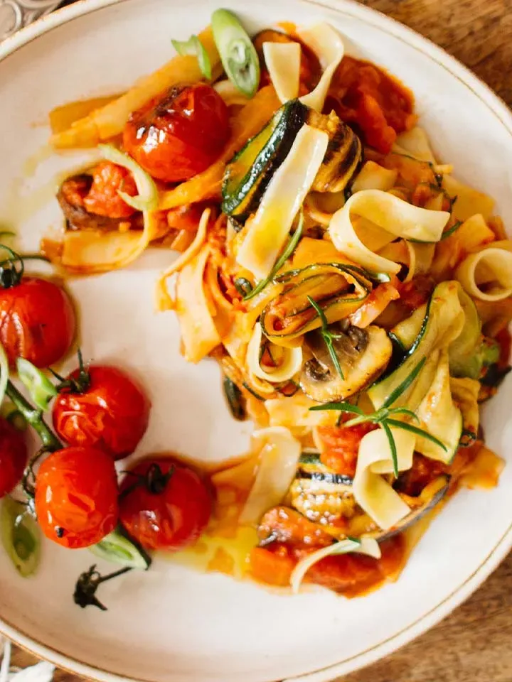Grillgemüse-Ratatouille mit Pasta und Kirschtomaten auf weißem Teller