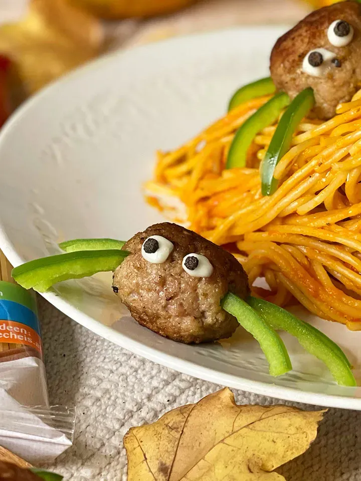 Halloweenrezept: Teller mit Spaghetti und Fleischbällchen als Spinnen mit grünen Paprikabeinen