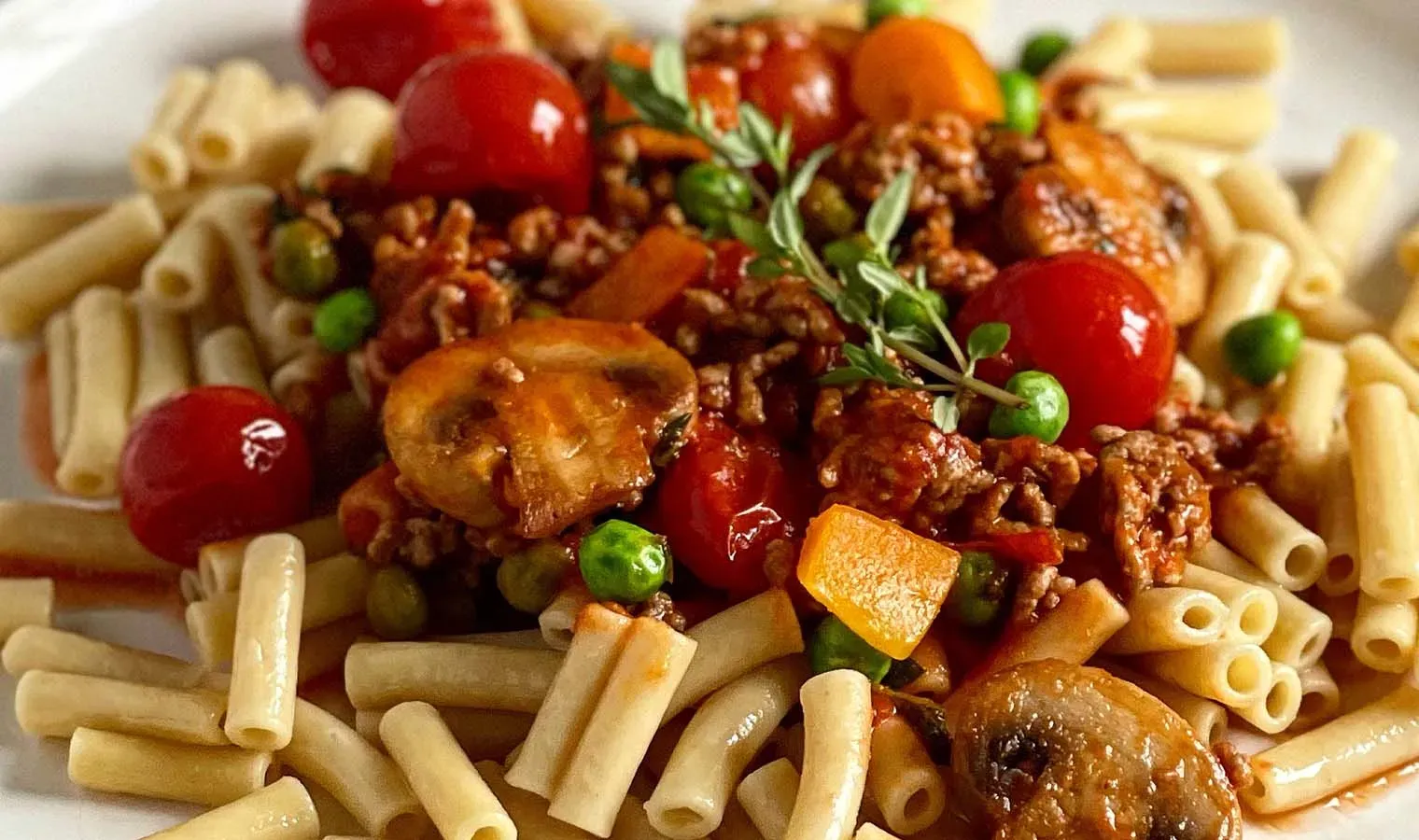 Nahaufnahme: Low-Carb-Hirtenmakkaroni mit Hackfleisch, Tomaten, Erbsen, Pilzen und Kräutern