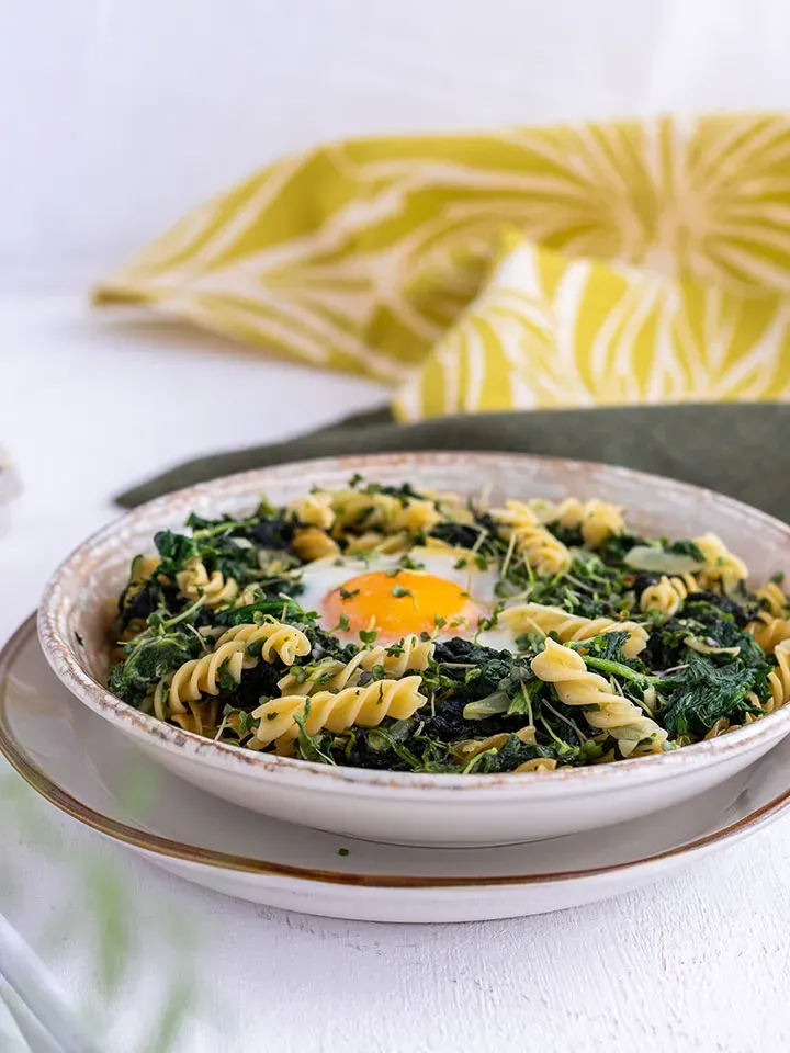 Low-Carb-Osterrezept: Nudeln mit Spinat und einem Spiegelei in der Mitte auf einem Teller