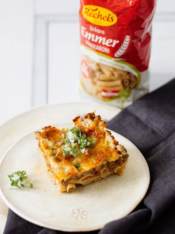 Ein Stück Nudelauflauf mit Emmer-Nudeln, Käse und Kräutern auf weißem Teller