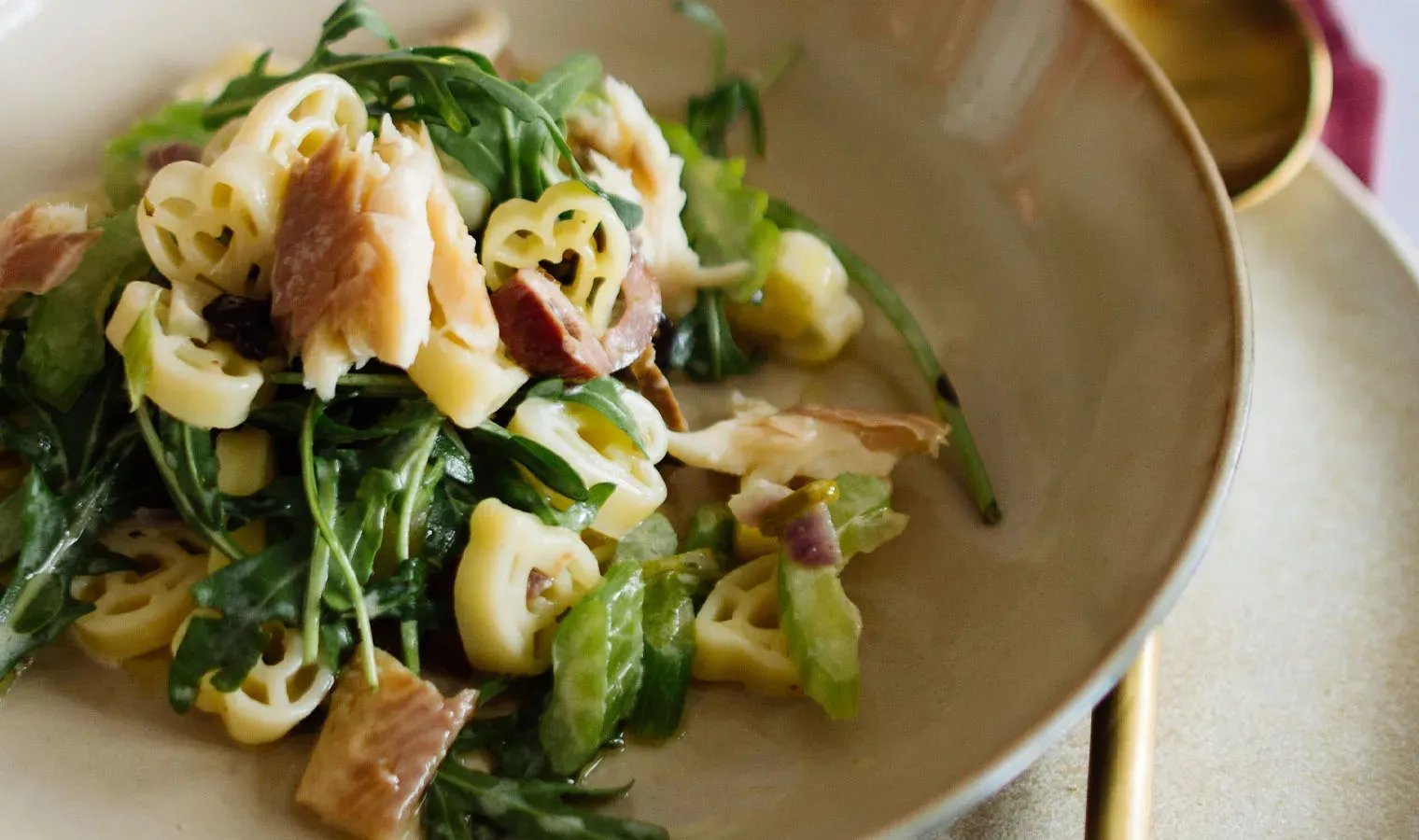 Nudelpfanne mit geräuchertem Fisch: Herznudeln mit Rucola auf einem Teller
