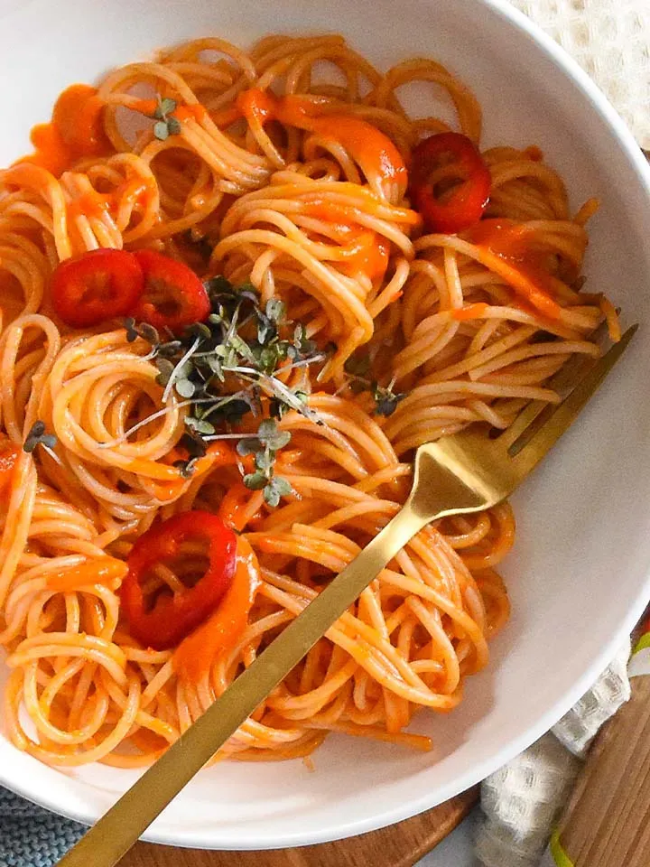 Veganes Nudelrezept mit Paprika: Spaghetti in Tomatensauce mit roten Chilischoten und Kräutern in einer weißen Schüssel