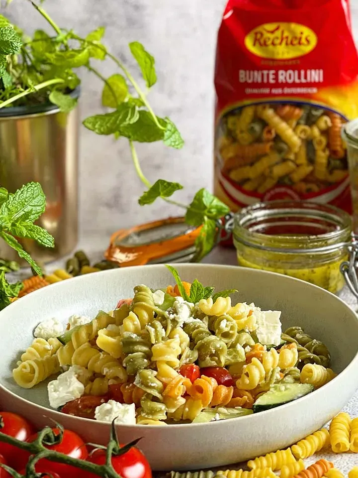 Griechischer Nudelsalat mit Tomaten, Gurken und Feta in weißer Schüssel