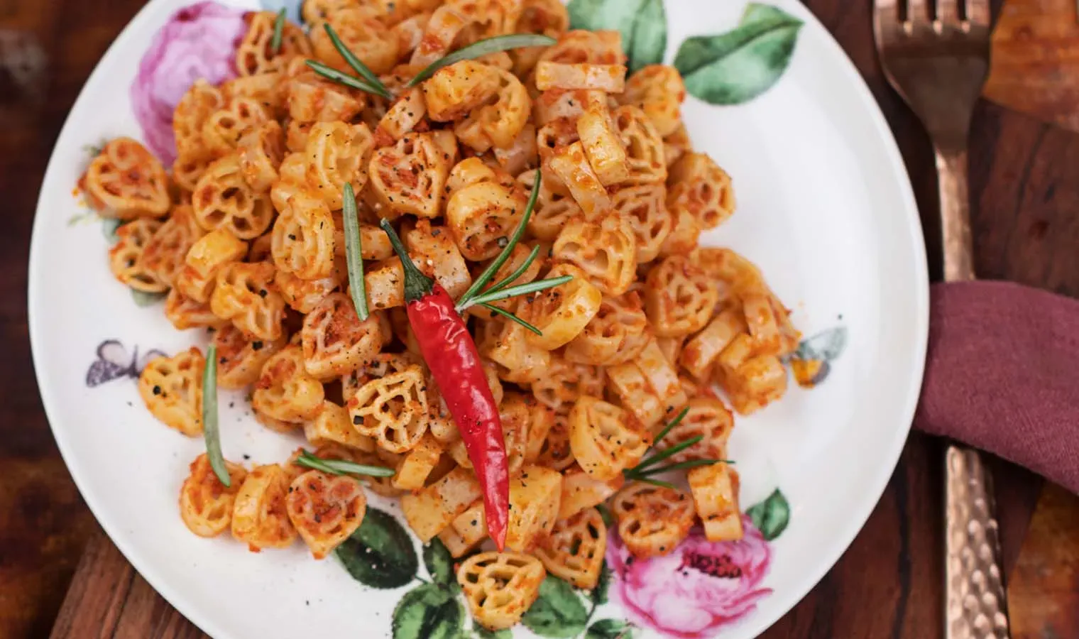 Selbstgemachtes Paprika-Chili-Pesto zu Pasta in Radform, garniert mit einer roten Chili