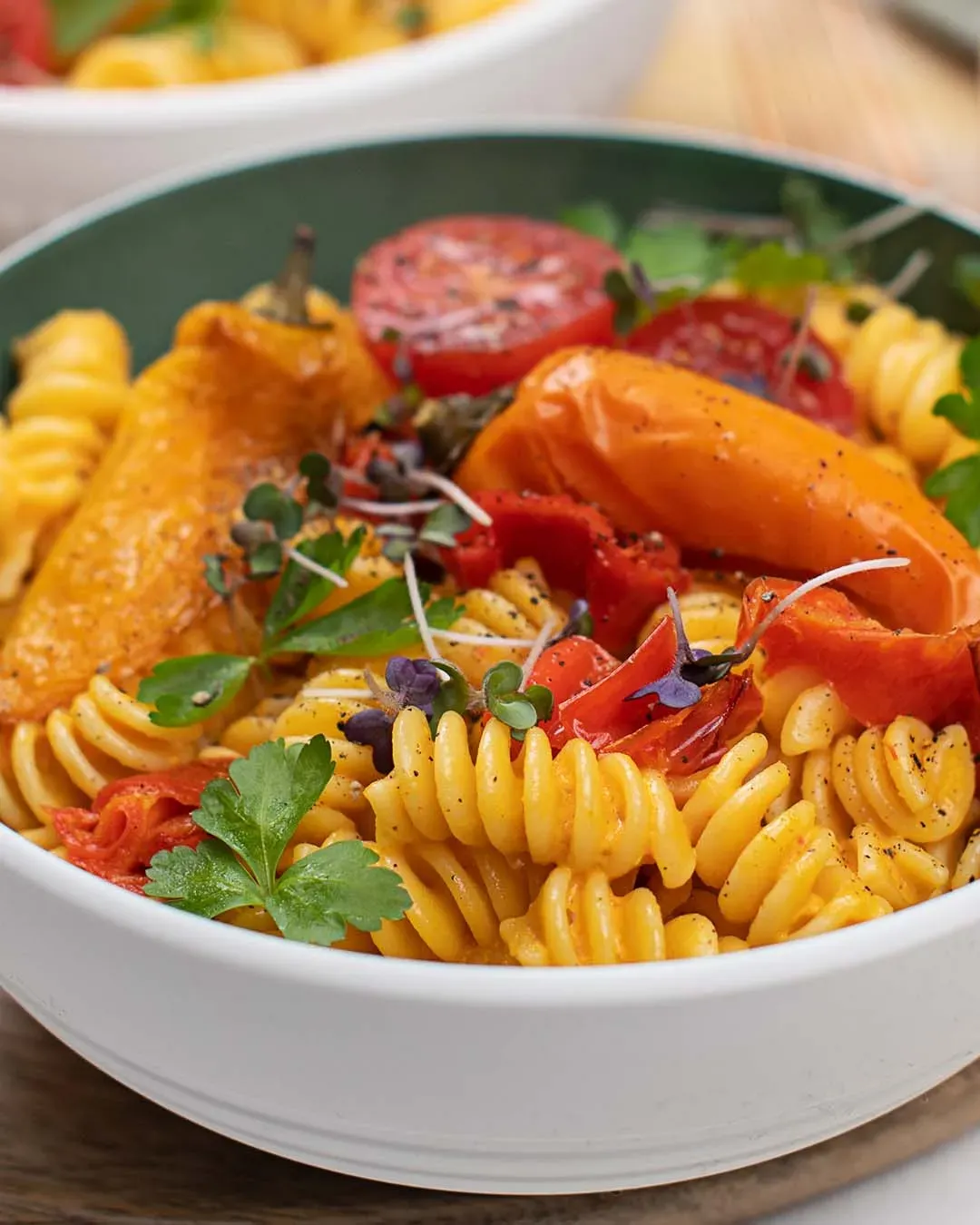 Paprikasauce mit Spiralnudeln, gerösteten Paprika, Tomaten und Kräutern in einer Schüssel