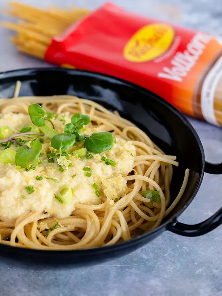 Pasta Alfredo mit Blumenkohl: Spaghetti mit cremiger Sauce und Kräutern in schwarzer Pfanne