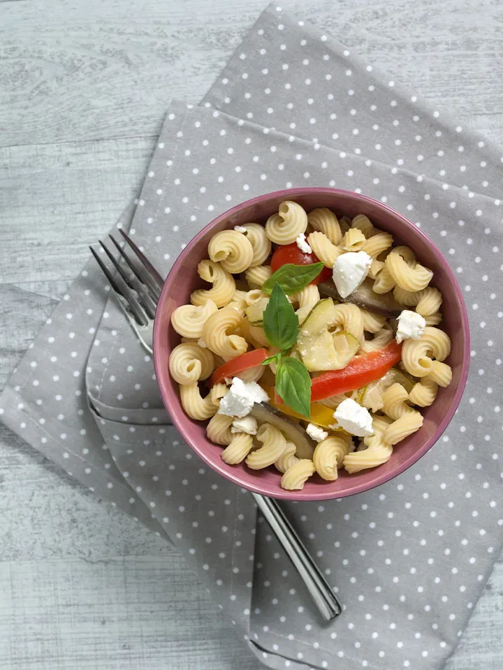 Low-Carb-Ratatouille mit Nudelsalat, Gemüse und Kräutern in einer Schüssel auf gepunktetem Stoff
