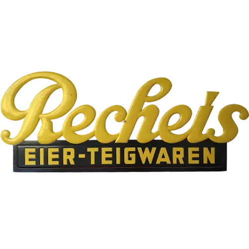 Historisches gelbes Schild mit Schriftzug Recheis Eier-Teigwaren auf weißem Hintergrund