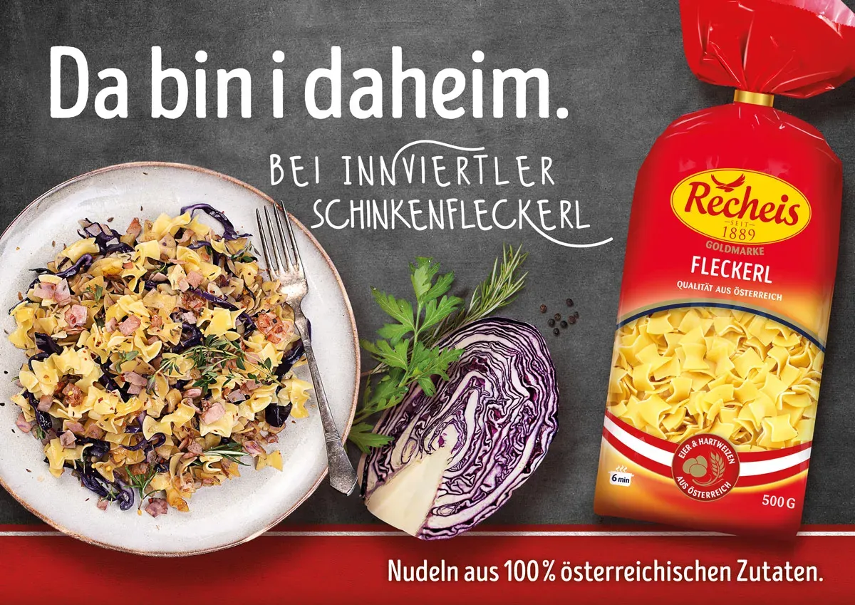 Innviertler Schinkenfleckerl mit Rotkohl und Kräutern auf Teller neben Packung Recheis Fleckerl Nudeln