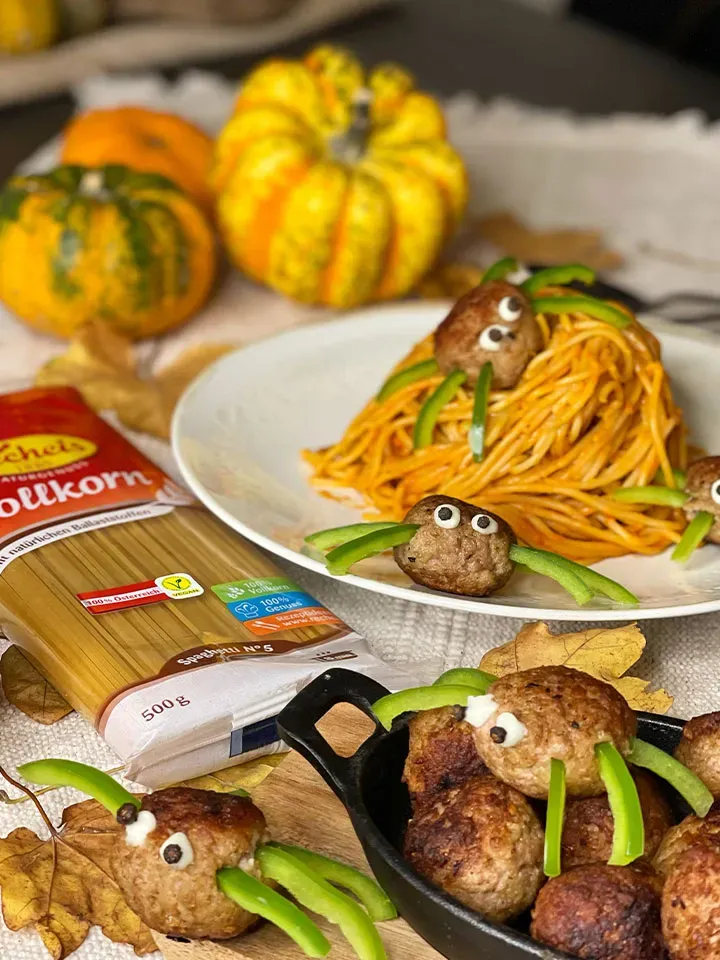 Kürbis-Spaghetti mit Fleischbällchen-Spinnen aus Fleischbällchen und grünen Paprikastreifen, dazu Kürbisse