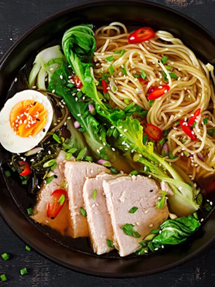 Ramen mit Pak Choi und Schweinefleisch in einer Schüssel mit gekochtem Ei und Chili