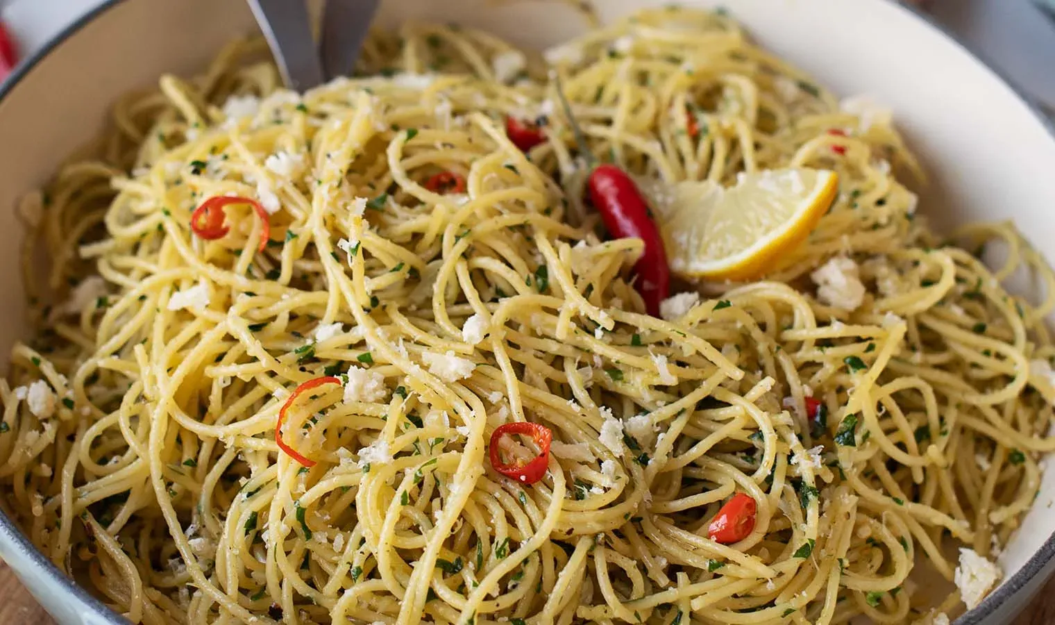 Nahaufnahme: Spaghetti aglio e olio mit Chili und Zitronenscheibe in einer Schüssel
