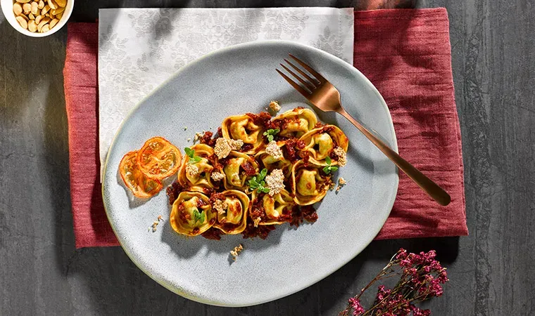 Tortelloni Spinat-Ricotta auf Tomaten-Erdnuss Pesto und Dinkelcrunch