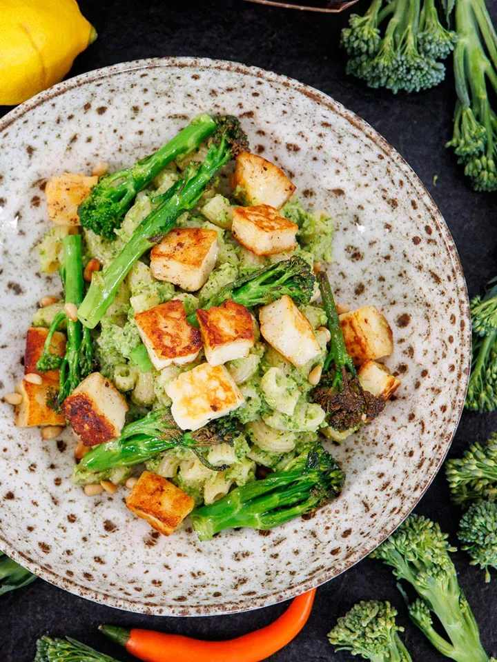 Vollkorn-Hörnchen mit Stangenbrokkoli-Pesto und gebratenem Halloumi auf einem Teller auf dunklem Untergrund